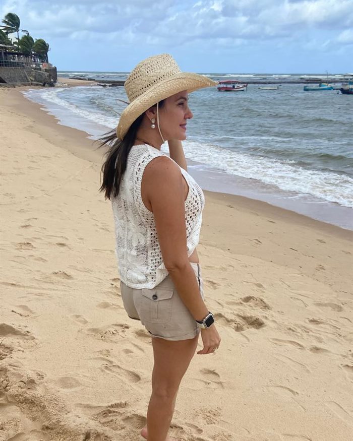 Dra. Luana Figuerêdo na praia, olhando o mar